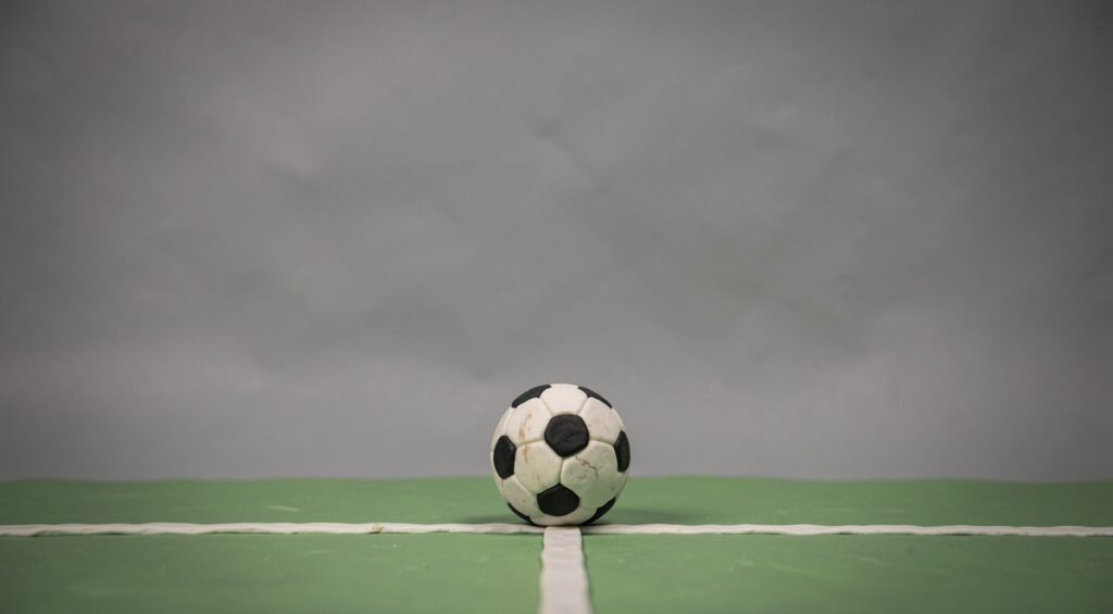 Ballon de foot sur le terrain. Sculpture en plasticine.