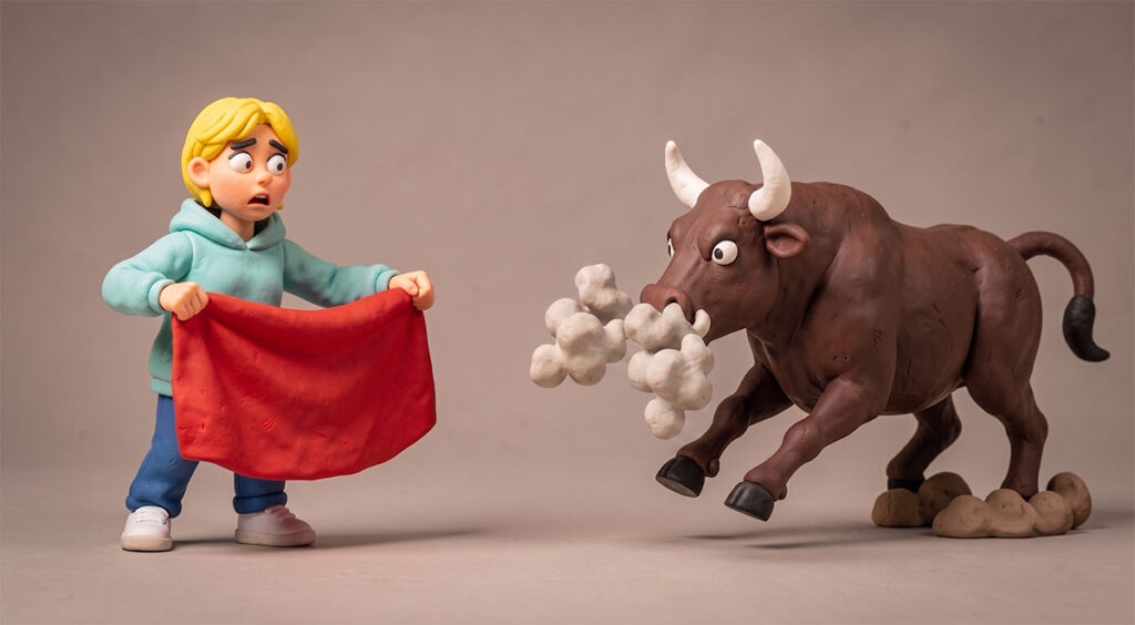 Une adolescente agite un drap rouge devant un taureau. Sculpture en plasticine.